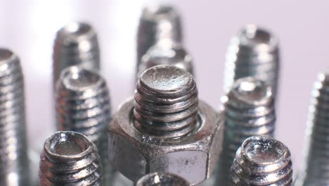 rotating group of galvanized metallic screws close-up. steinless steel bolts isolated on white background.