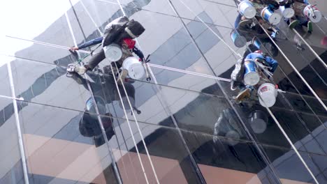 equipo de trabajadores reparando ventanas en un edificio alto