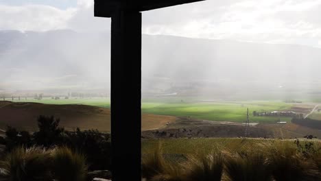 sun breaking through rain mist overlooking valley of mountains