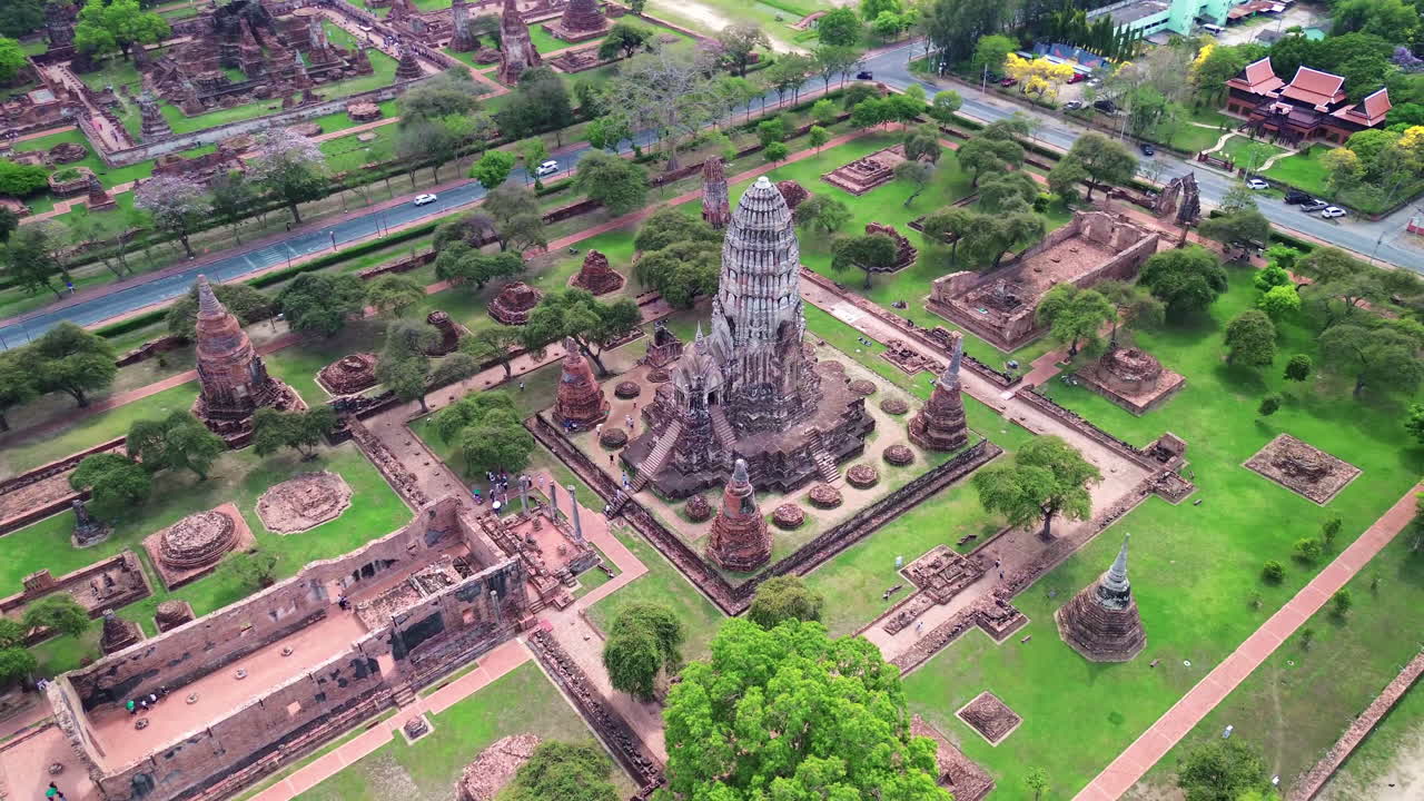 Aerial medium orbit establishing of temple complex and ancient ruins of Ayutthaya, Thailand with surrounding greenery