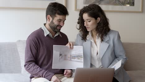 front view of two architects talking with client via laptop