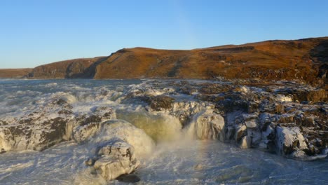 aerial view of frozen urriðafoss waterfall in iceland with wild river