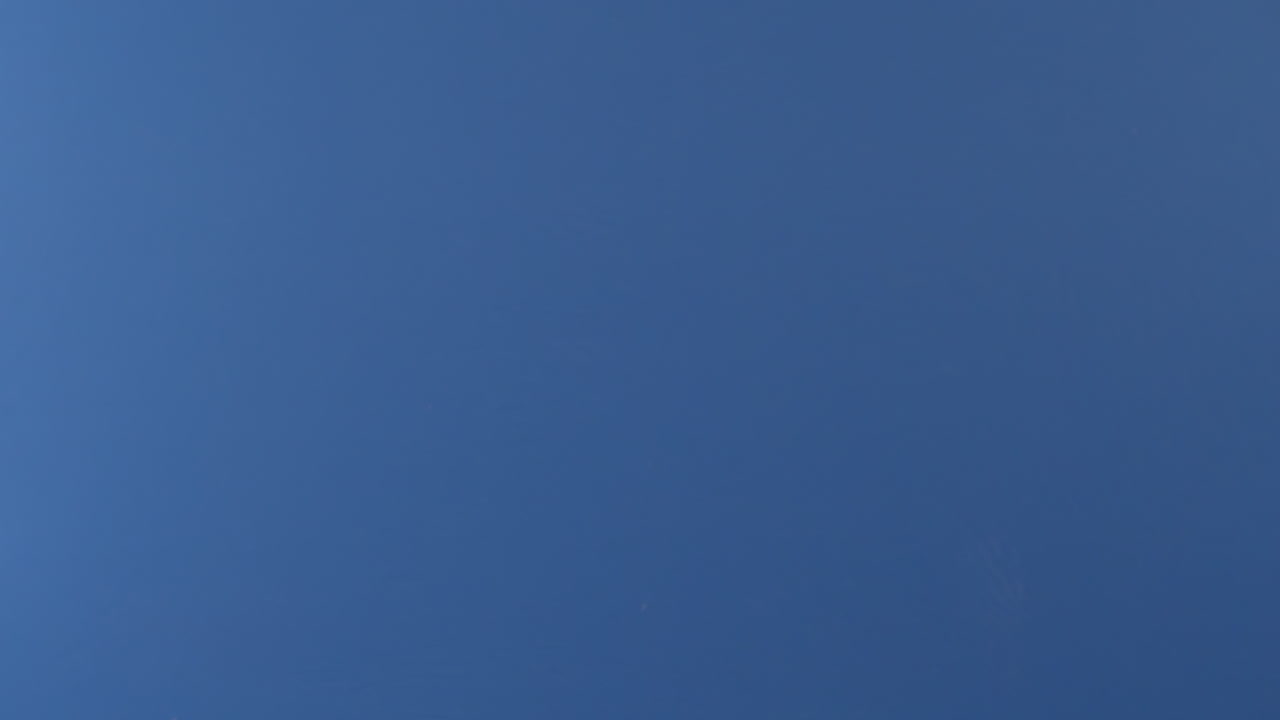 una pizza de pepperoni voladora vuela a cámara lenta frente a una pantalla azul