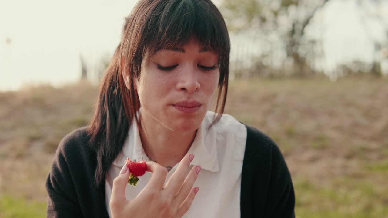 Happy Woman Eats Strawberry at a Picnic