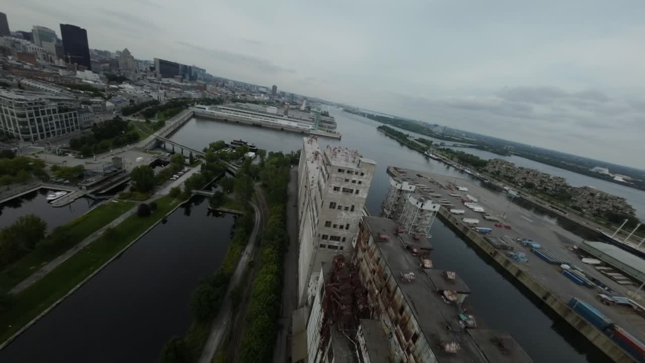 FPV drone pushes dynamically over old waterfront buildings at abandoned Silo 51, industrial charm and scenic views of Montreal's Old Port.