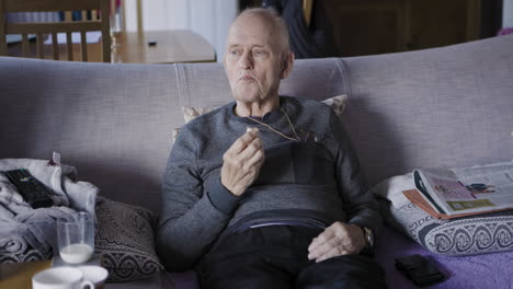 elderly man sitting on couch indoors