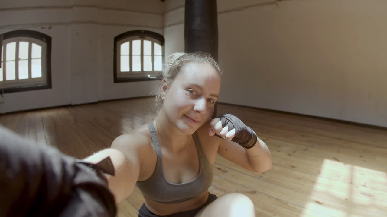 pov de boxeadora alegre tomando una selfie después del entrenamiento en el gimnasio