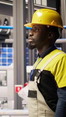 vertical video man holding toolbox walking in factory, inspecting systems