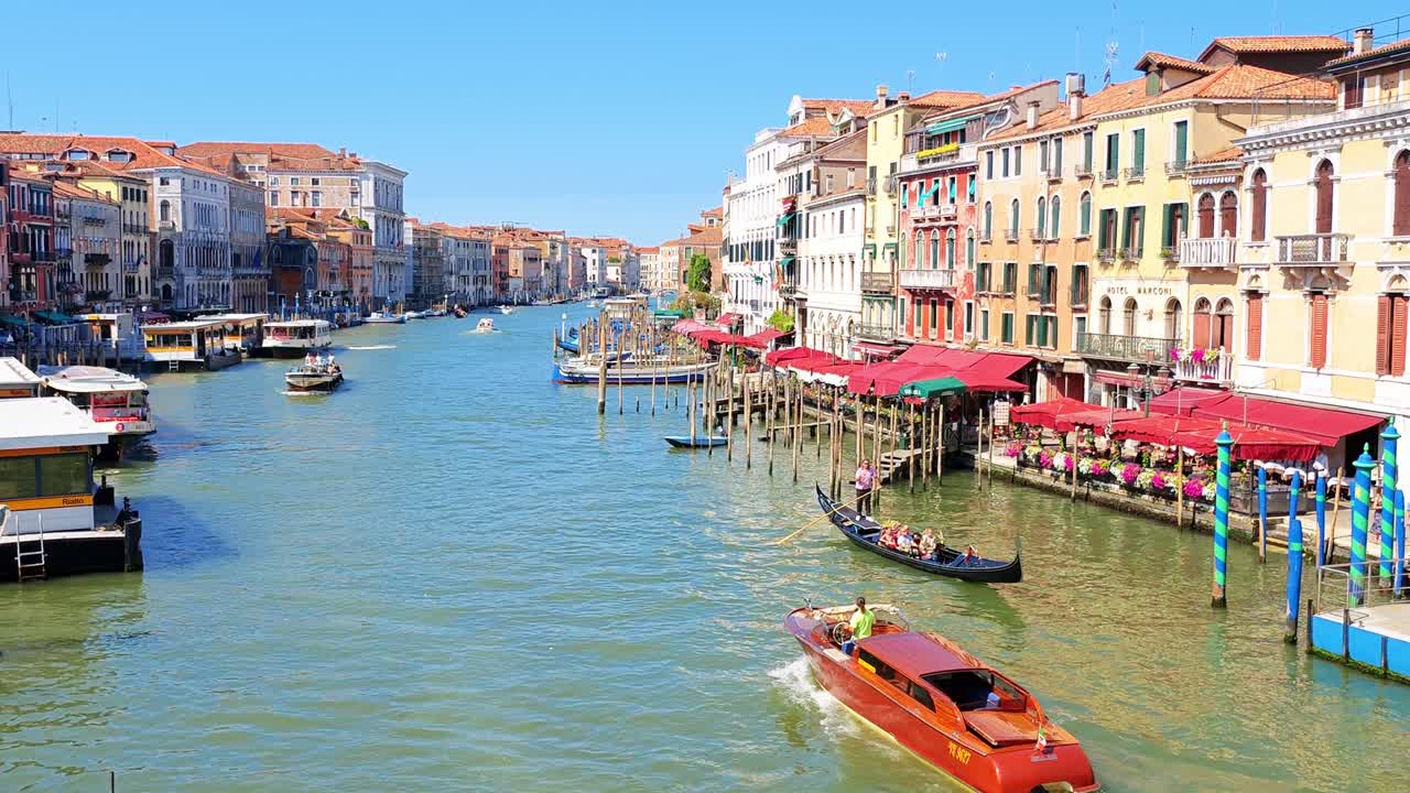 Busy canal with boats gliding past colorful facades, visitors exploring the famous waterways and historic sights