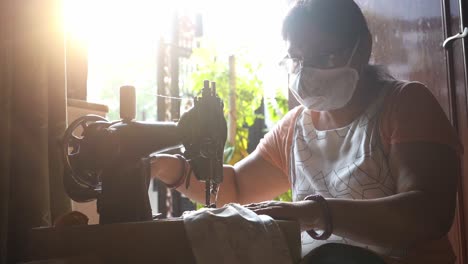 Woman-Wearing-A-Face-Mask-On-A-Traditional-Manual-Sewing-Machine-In-Agra,-State-Of-Utter-Pradesh,-India