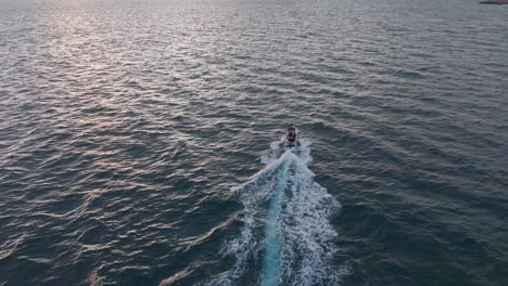 A-boat-cruising-the-serene-waters-off-the-coast-of-nervi,-genoa,-italy-at-dusk,-aerial-view