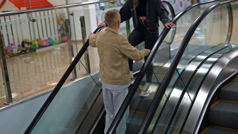 young people on an escalator in a shopping mall