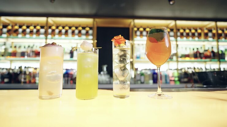 Quattro cocktail colorati allineati su un bancone del bar