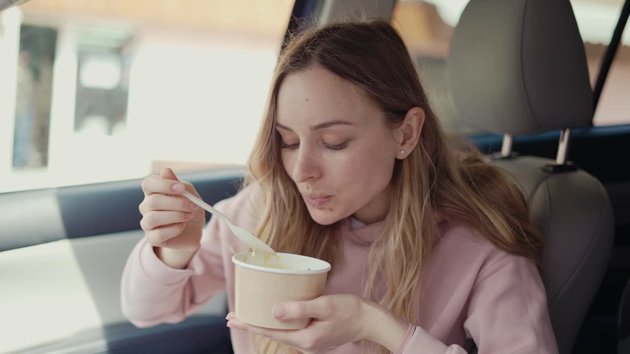 mujer comiendo dentro del coche estacionado