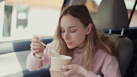 woman having her meal inside the parked car