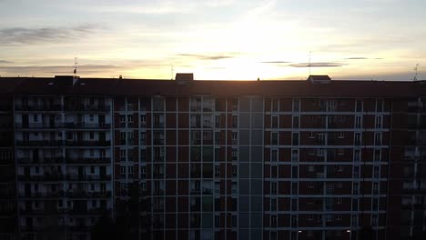 Apartment-building-and-silhouette-of-Milan-city-skyline-reveal,-aerial-ascend-view