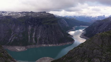 drone flying over trolltunga - 700 meter cliff above lake ringedalsvatnet