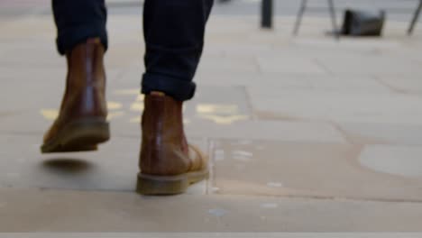 Tracking-Shot-of-Feet-Walking-Over-One-Way-Floor-Marking-In-Oxford-England