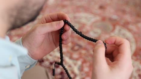 a hand praying with beads for allah