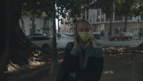 woman in mask arguing when talking on the phone outside