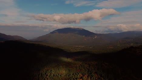 Aerial-vibrant-view-of-a-lonely-mountain-and-a-multi-colored-coniferous-forest-on-a-clear-sunny-day