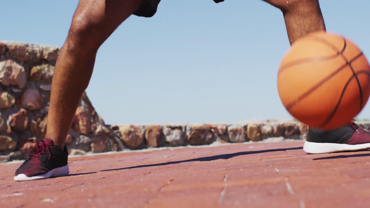 hombre afroamericano senior ejercitando jugando al baloncesto junto al mar