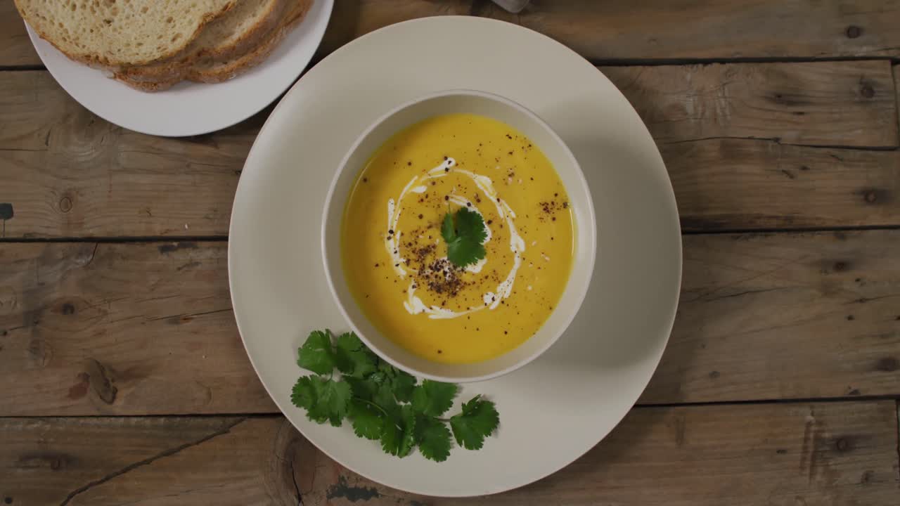 video de sopa de verduras con crema en un cuenco en una mesa de madera con decoraciones