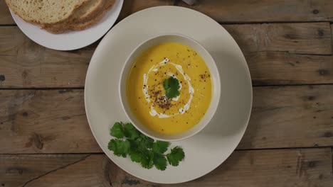 Video-of-cream-vegetable-soup-in-bowl-on-wooden-table-with-decorations