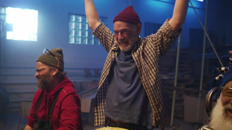 men celebrating and drinking beer in a workshop
