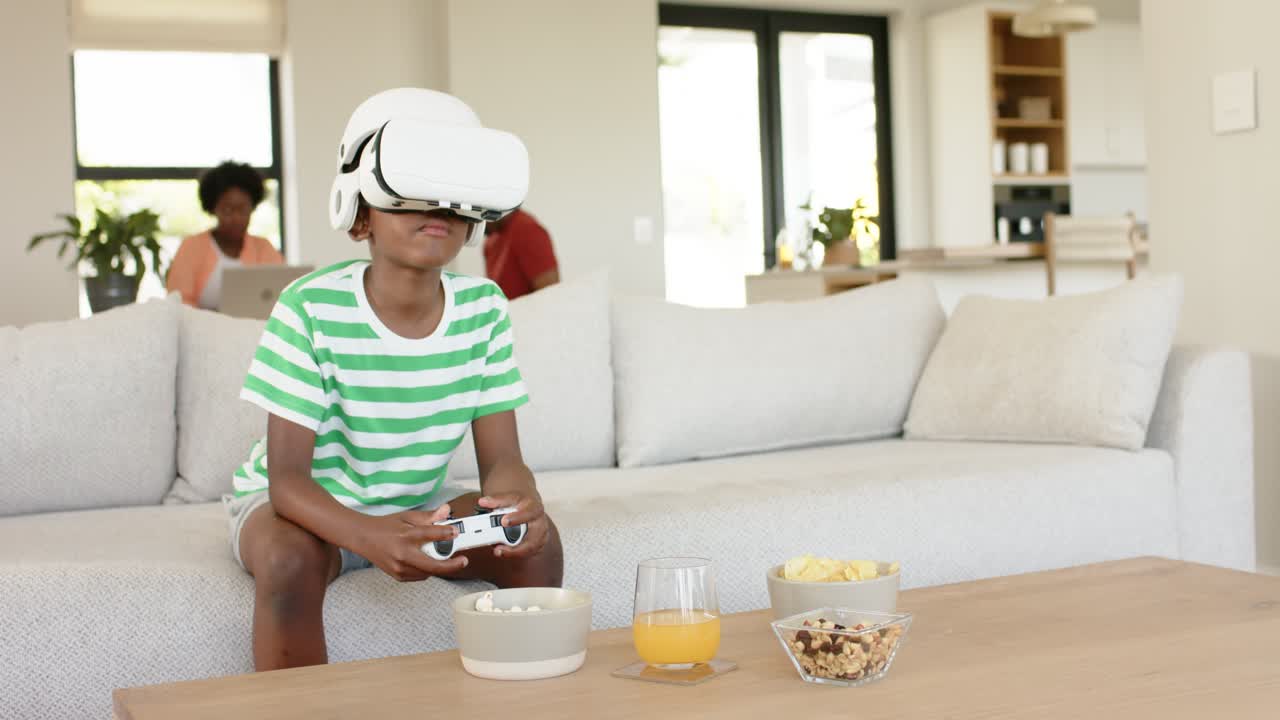 Ragazzo afroamericano con visore VR che impugna un controller a casa per il gioco virtuale