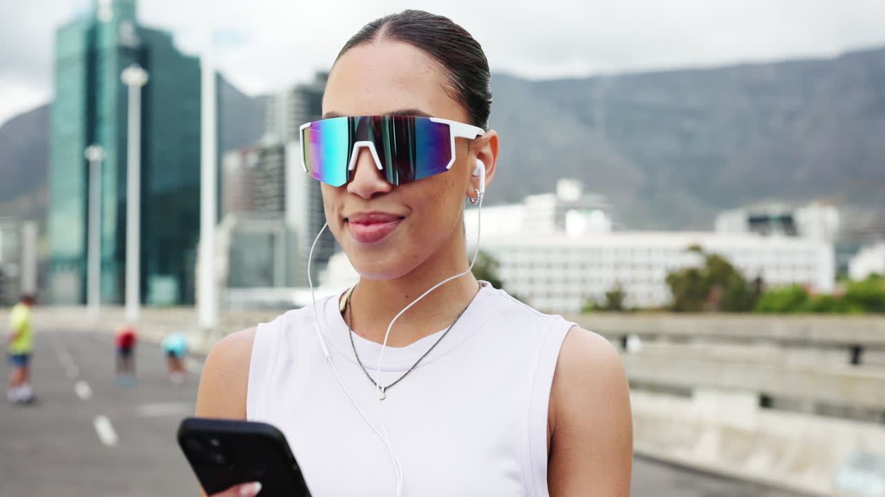 Smiling Woman in Sporty Sunglasses Listening to Music on Smartphone