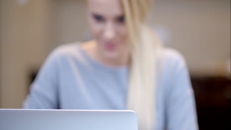 mujer joven sonriente trabajando en una computadora portátil