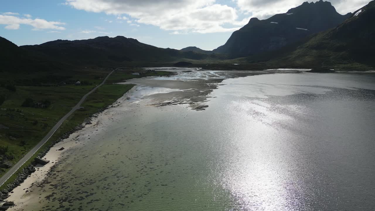 해변 위의 산을 향해 북유럽의 노르웨이 로포텐의 피요르드 위로 앞으로 날아갑니다.