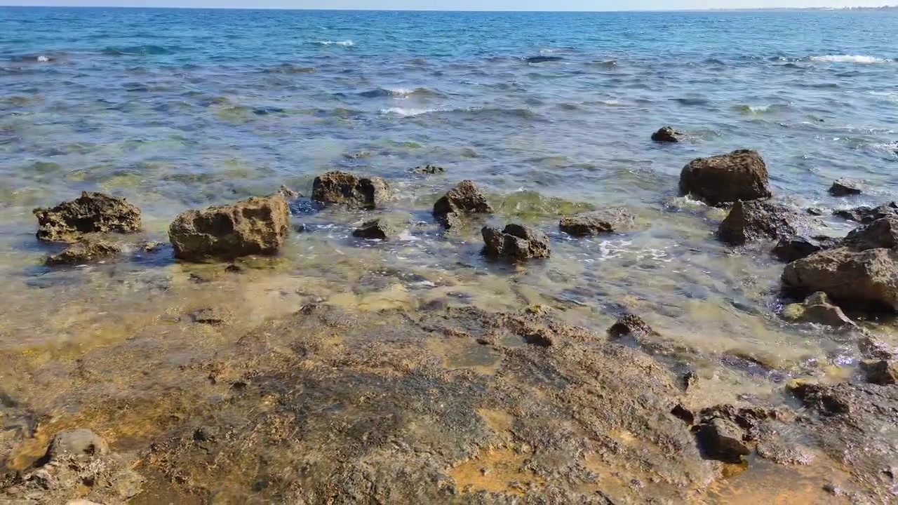 Onde delicate che si infrangono su una costa rocciosa.
