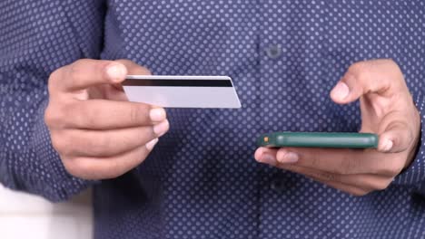 person paying with credit card and mobile phone