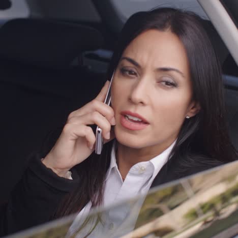 Serious-female-executive-on-phone-in-limousine