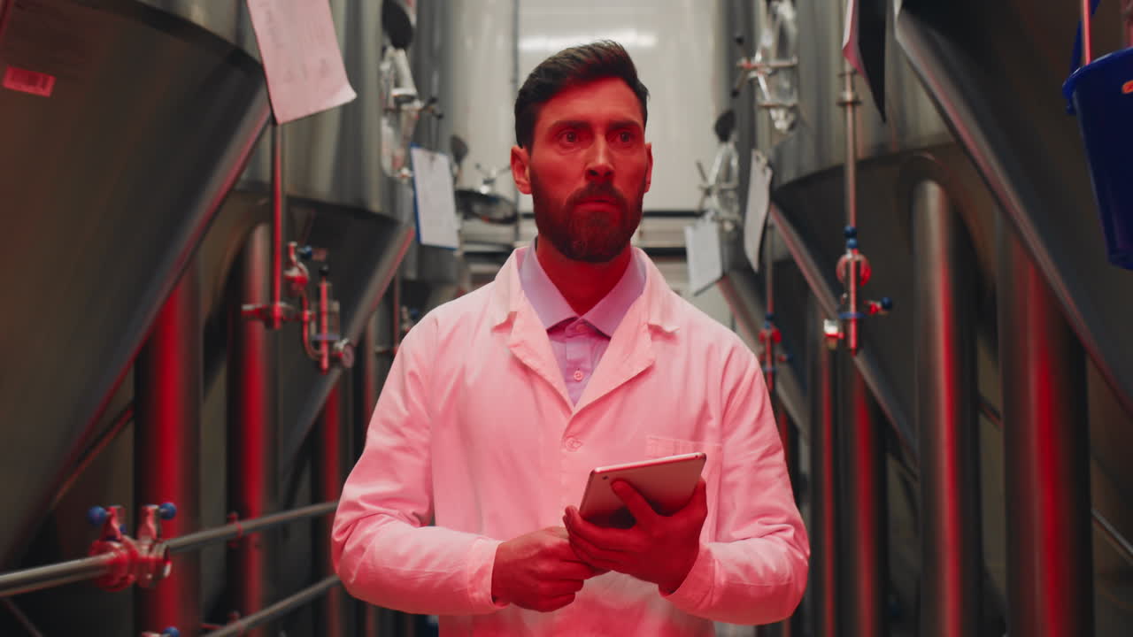 Scientist at a brewery inspecting tanks with a tablet