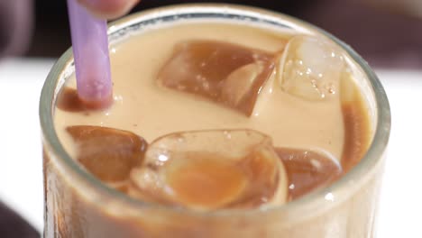 iced coffee with ice cubes and purple straw