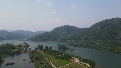 beautiful aerial shot flying in rural south korea with mountains and river