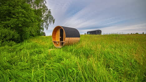 Sommerlandschaft-Sonnenuntergang-Zeitraffer-Mit-Sauna-Auf-Einer-Grünen-Wiese,-Blauer-Himmel