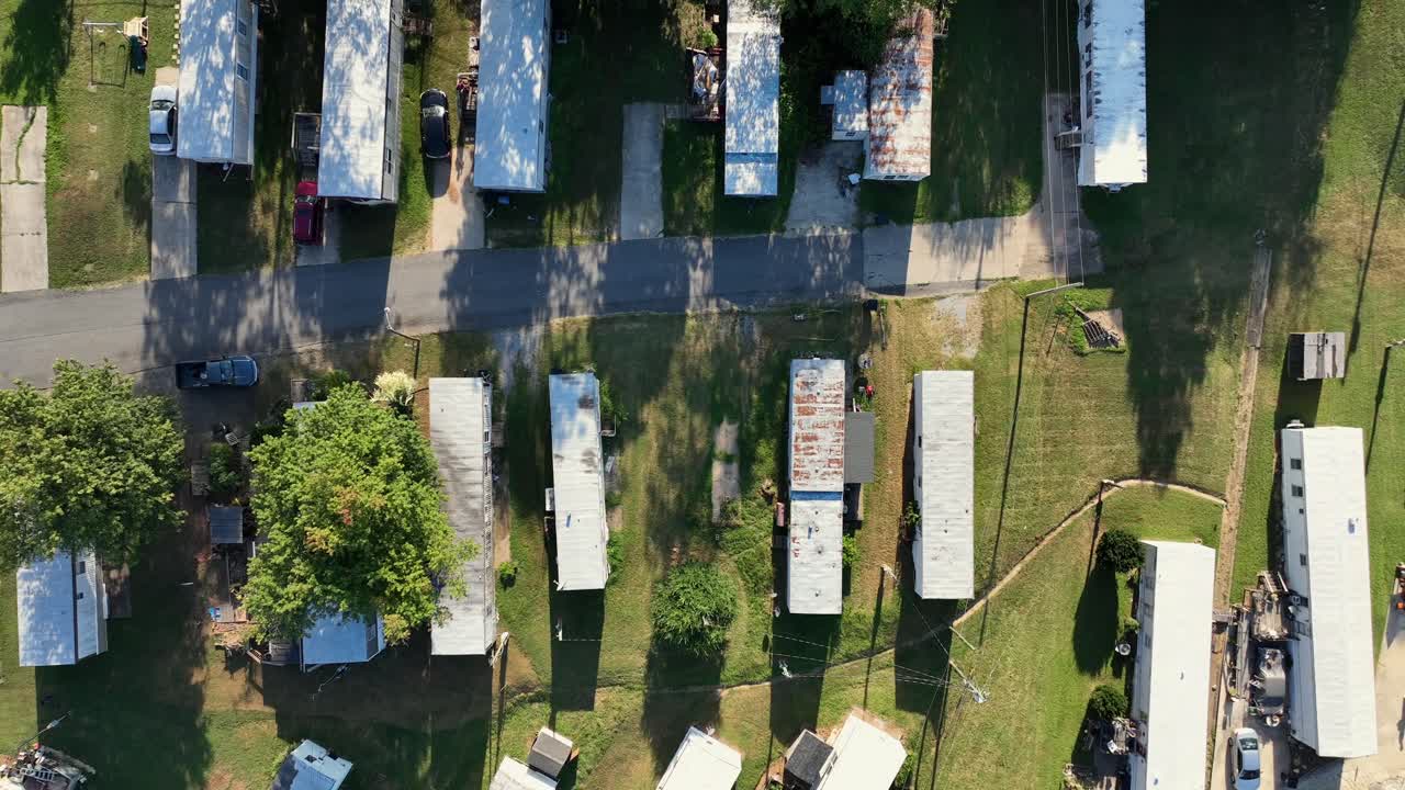 Tiny and rusty mobile trailer homes in dense populated neighborhood. Sunset time in summer. Aerial top down rising shot. Virginia state in USA. Low-income residential area in Suburb