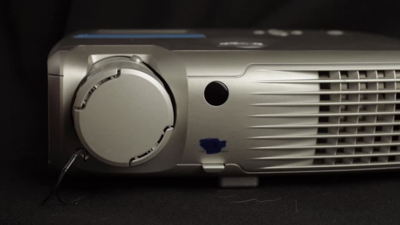 Hand adjusts projector lens to prepare for presentation close up