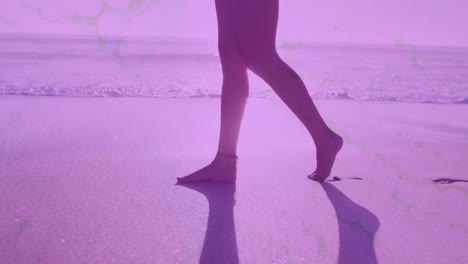 ondas digitales contra la sección baja de la mujer caminando por la playa
