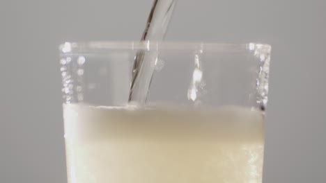 apple hard cider drink being poured into pint glass