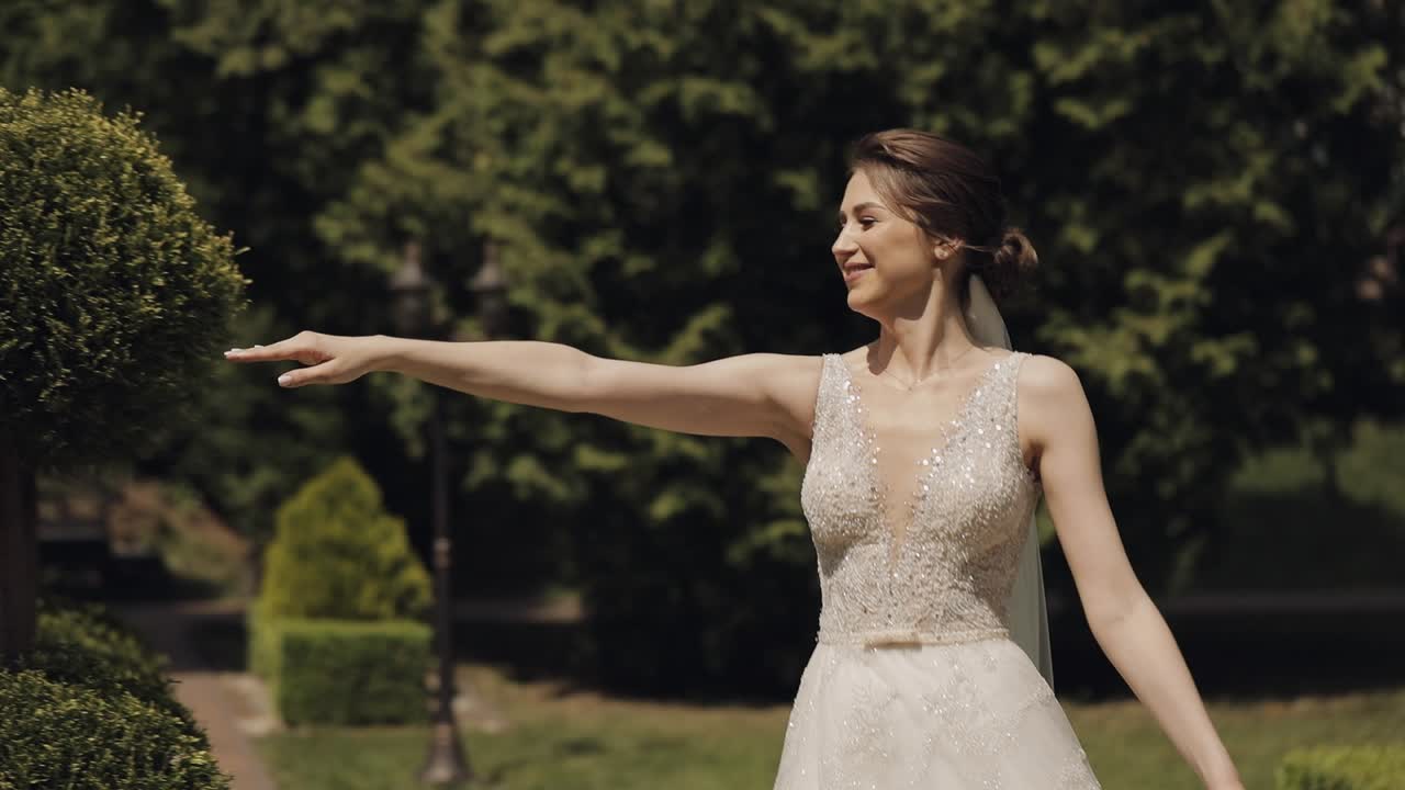 Sposi, sposo caucasico e sposa che camminano, si abbracciano e si baciano in un parco, coppia di sposi