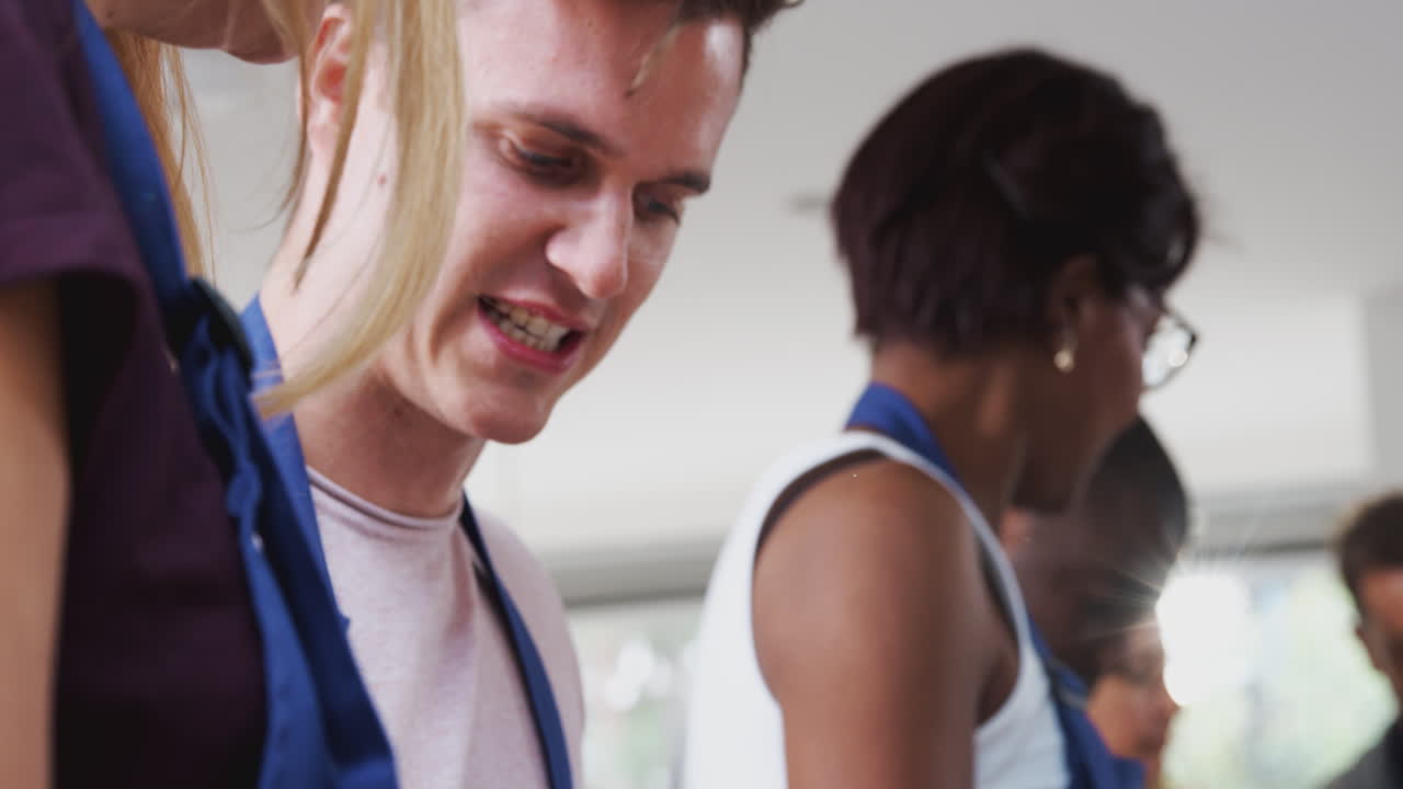hombre y mujer participando en una clase de cocina degustando comida