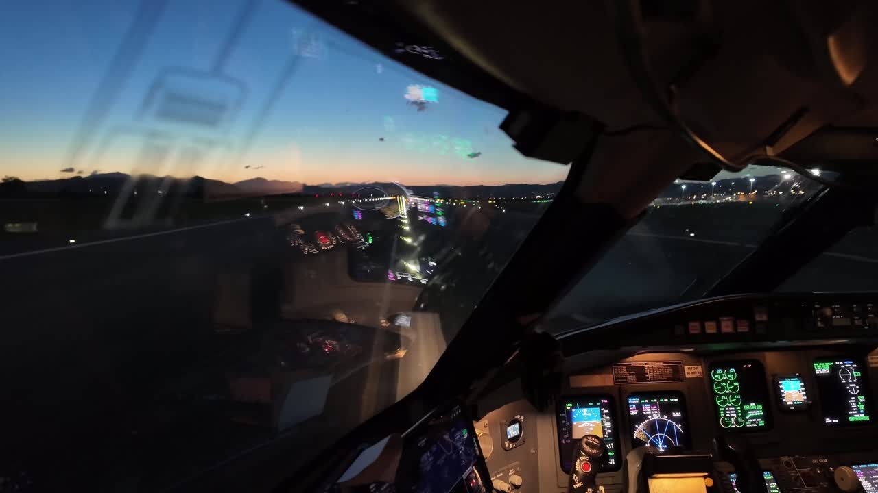An immersive pilot’s view taken from inside a jet airplane exiting the runway after landing at dusk.