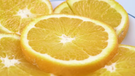 Close-up-fresh-valencia-orange-sliced-with-white-background-shallow-focus-and-slowly-rotating