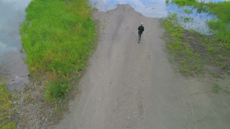 aerial view of mature woman walking near a lake 4k