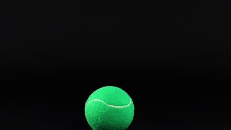 a series of frames showing a green tennis ball suspended in mid-air against a dark backdrop.